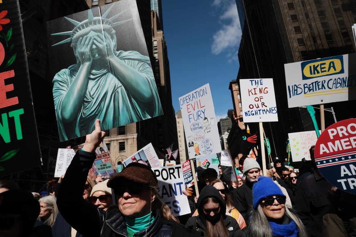 Protesters hold signs as they participate in a 'No Kings' protest at New York City on March 28, 2026.