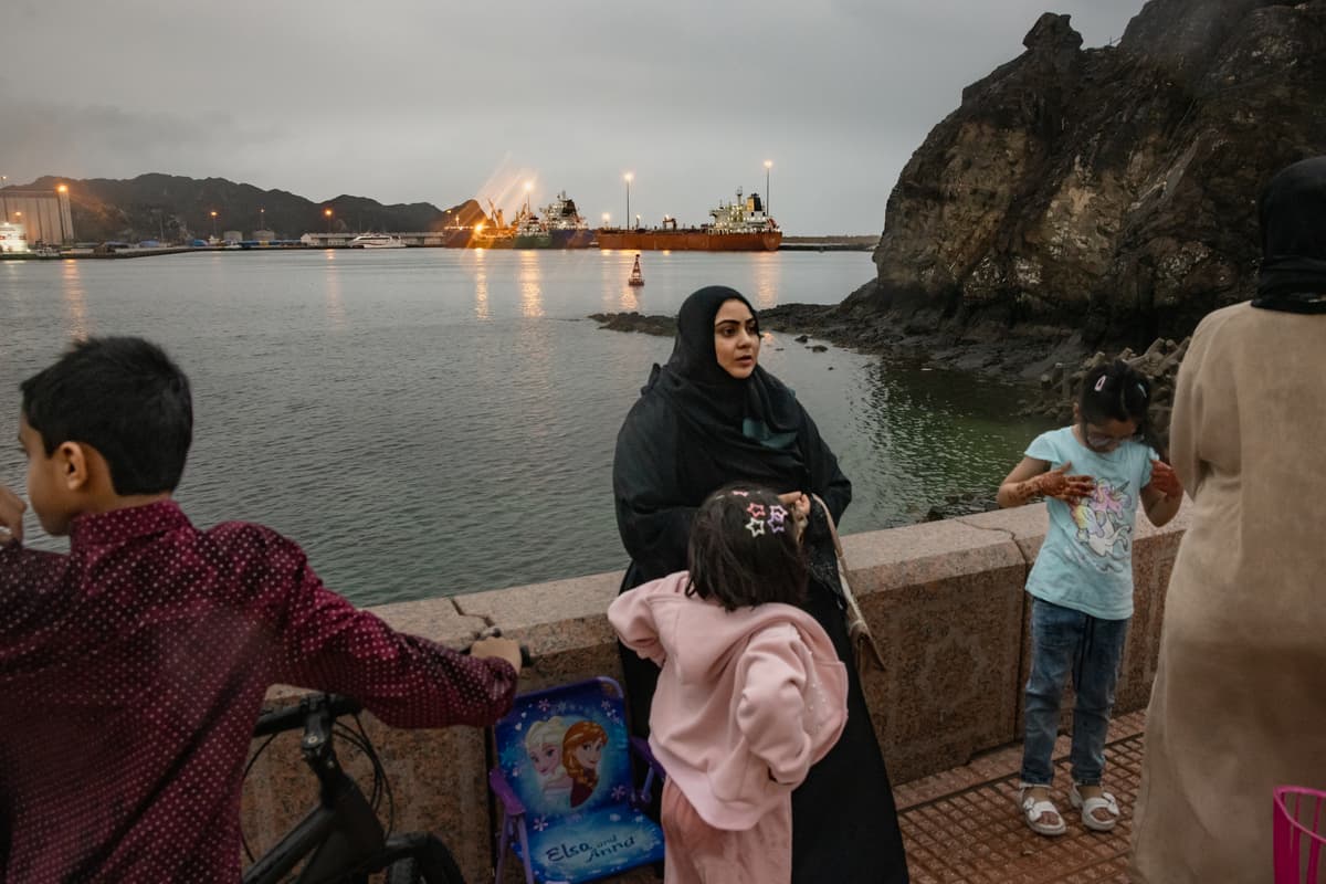 A bulk carrier sits anchored as families gather at Sultan Qaboos Port on March 23, 2026 in Muscat, Oman. 
