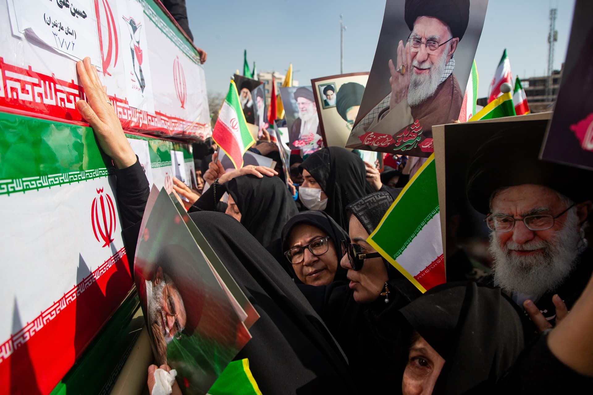 Mourners, some holding pictures of the late Ayatollah Ali Khamenei, reach out to coffins during a funeral for people killed during the U.S.–Israeli military campaign at Isfahan, Iran, on March 5, 2026.