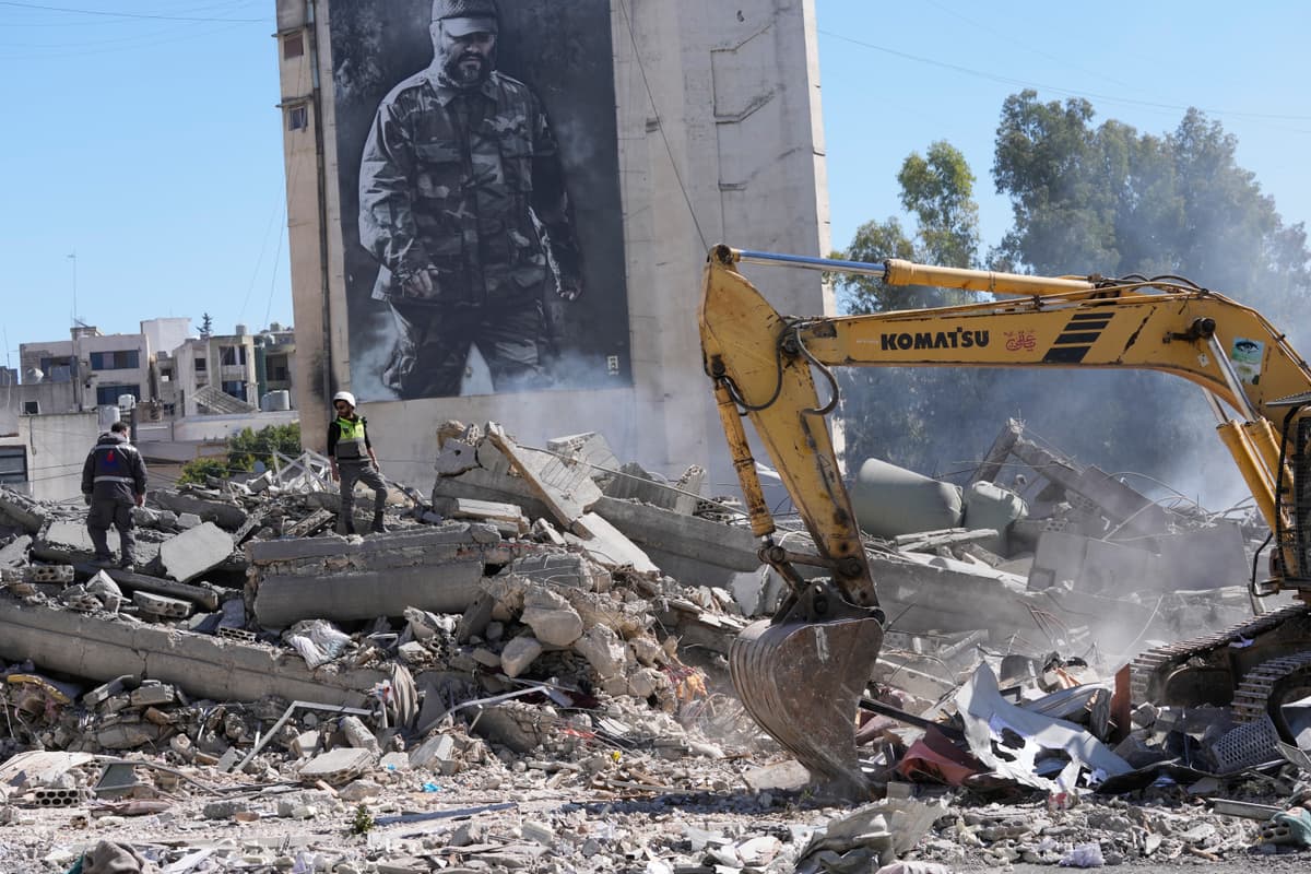 A poster shows the late Hezbollah military commander Imad Mughniyeh next to remains of a building hit by an Israeli airstrike at Nabatiyeh town, south Lebanon, on March 5, 2026.