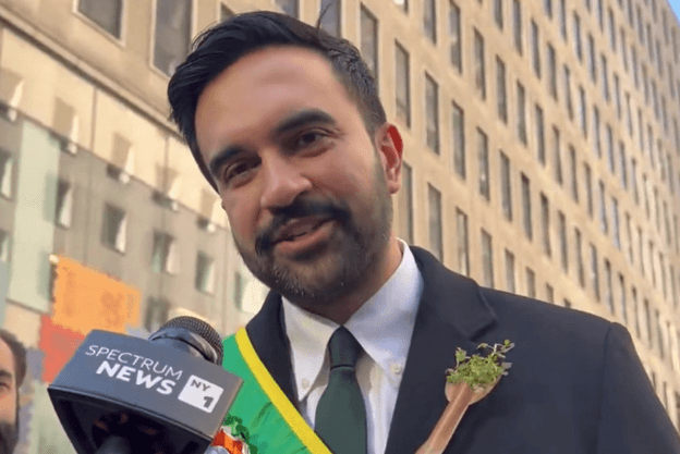 Mayor Zohran Mamdani, wearing a sash in Ireland’s national colors, speaks to a reporter during the St. Patrick’s Day parade at Manhattan on March 17, 2026.