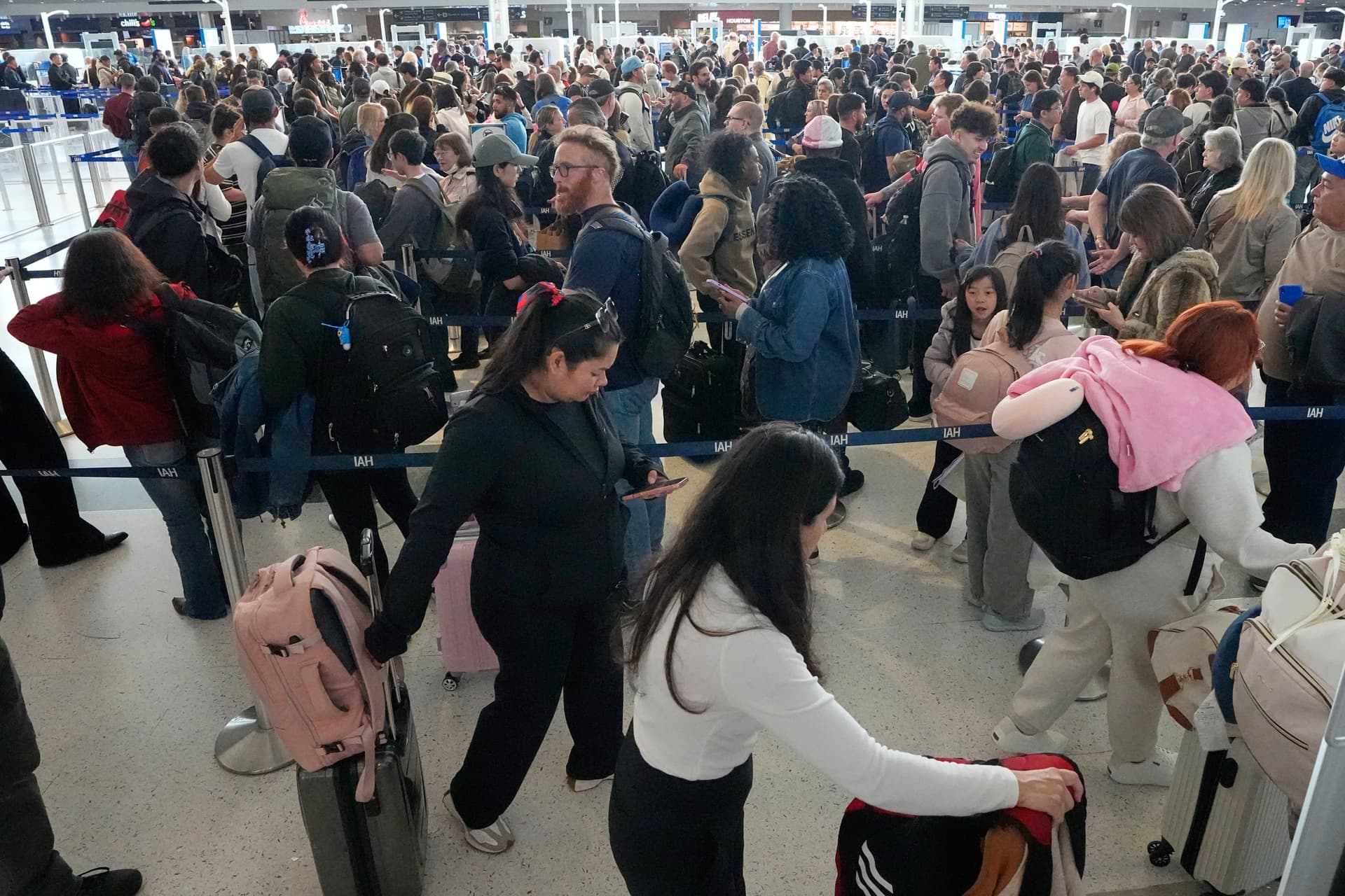Passengers wait in a long security checkpoint line at George Bush Intercontinental Airport Thursday, March 19, 2026, in Houston.