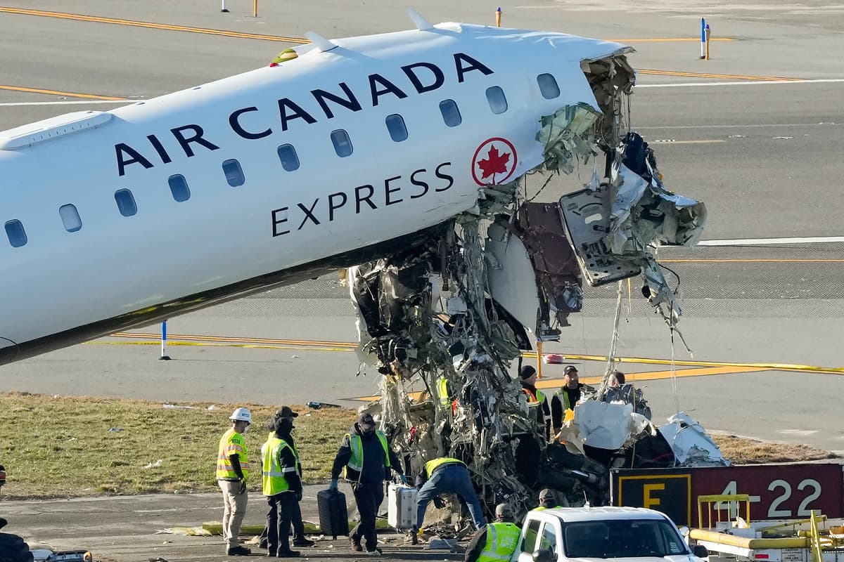 NTSB officials and aircraft maintenance workers inspect the wreckage of an Air Canada Express jet at LaGuardia Airport in New York.