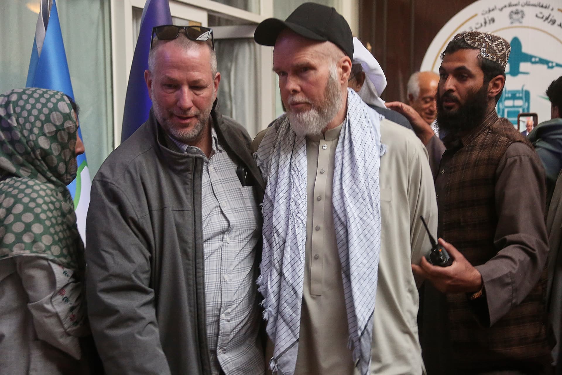 American Dennis Coyle, second from right, is accompanied by an unidentified person after being released by Afghanistan's Taliban authorities.