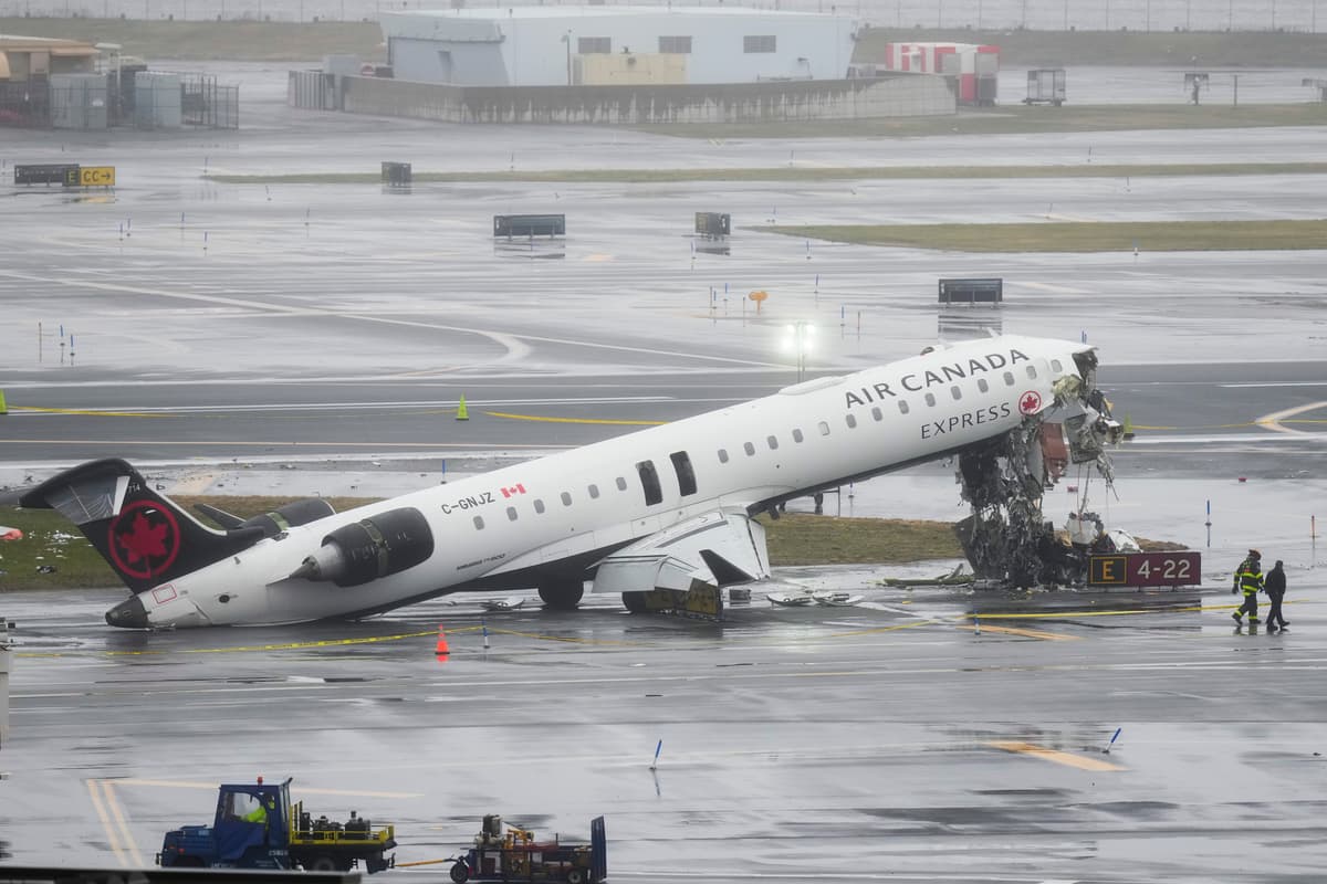 Investigators walk the site, Monday, March 23, 2026, where an Air Canada jet came to rest after colliding with a Port Authority fire truck at LaGuardia Airport, after landing Sunday night in New York.