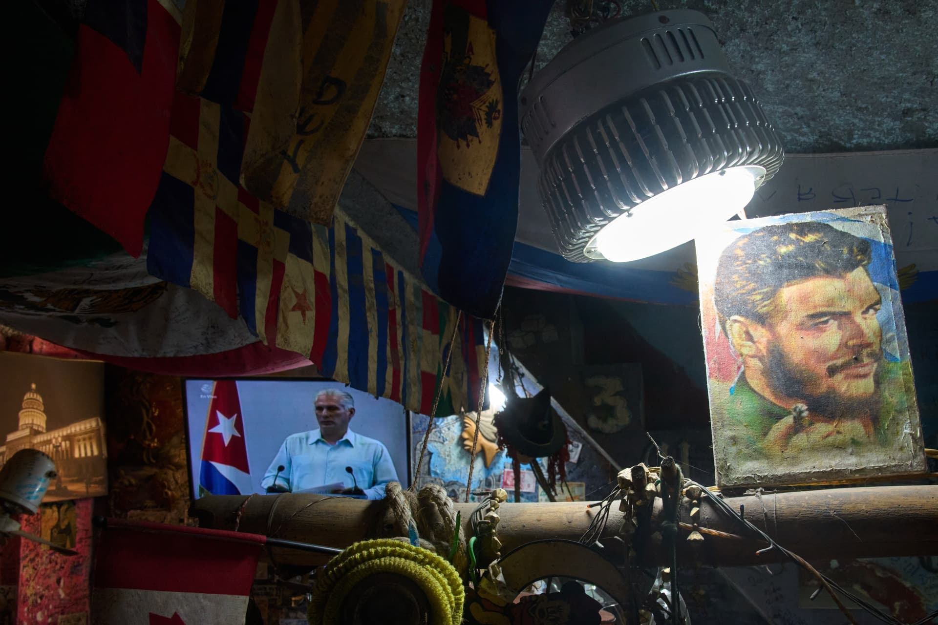 An image of Marxist revolutionary Ernesto "Che" Guevara stands next to a TV showing Cuban President Miguel Díaz-Canel speaking, inside a souvenir shop at Havana, Cuba, on March 13, 2026. 