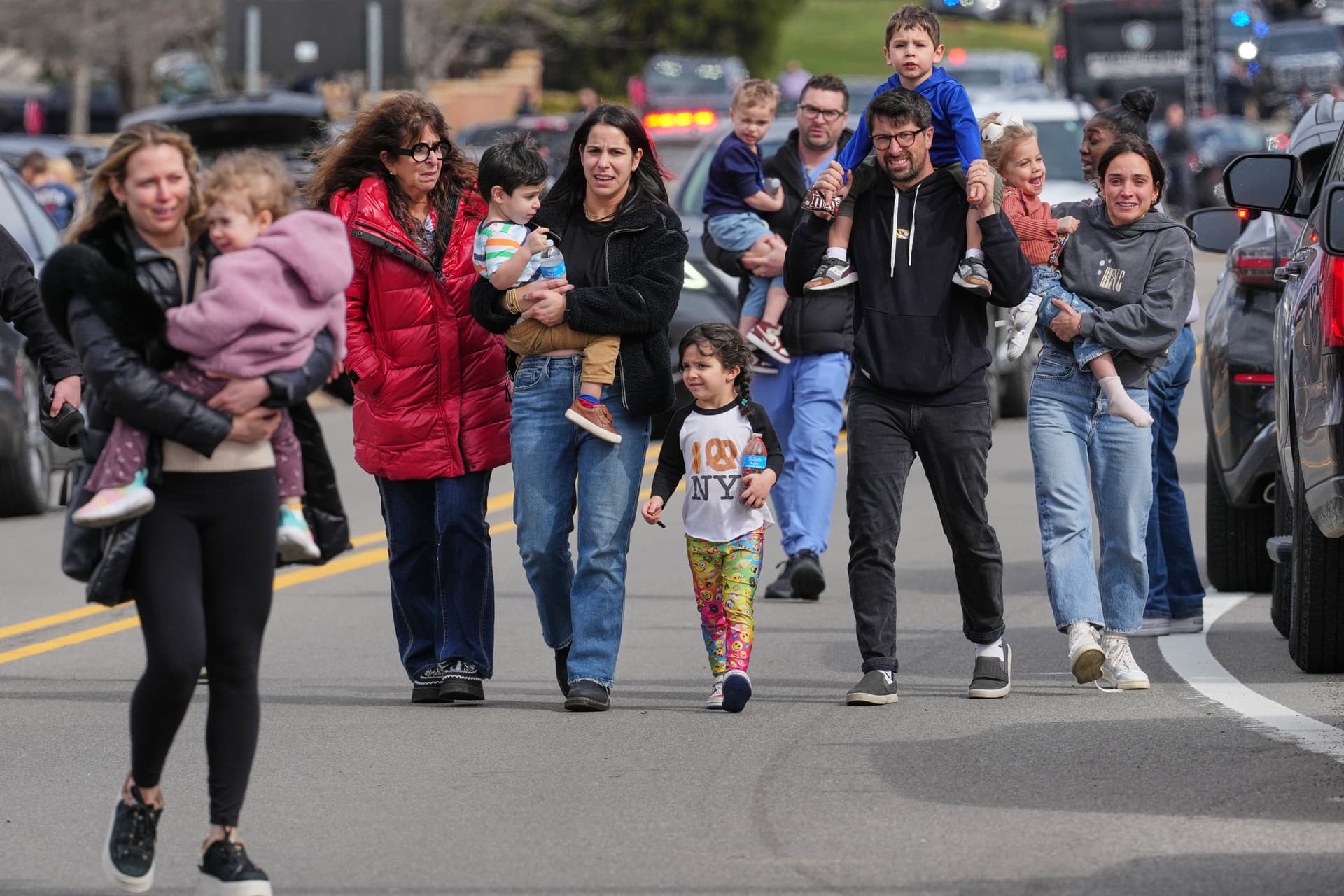 Law enforcement escort families with children away from the Temple Israel synagogue Thursday, March 12, 2026, at West Bloomfield Township, Michigan.