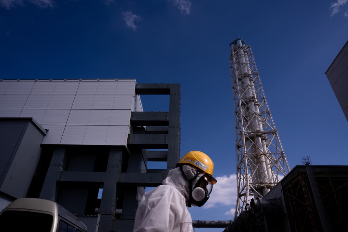 A worker walks past the Unit 4 reactor at the Fukushima Daiichi nuclear power plant, operated by Tokyo Electric Power Company (TEPCO), in Okuma, Fukushima Prefecture, February 12, 2026.