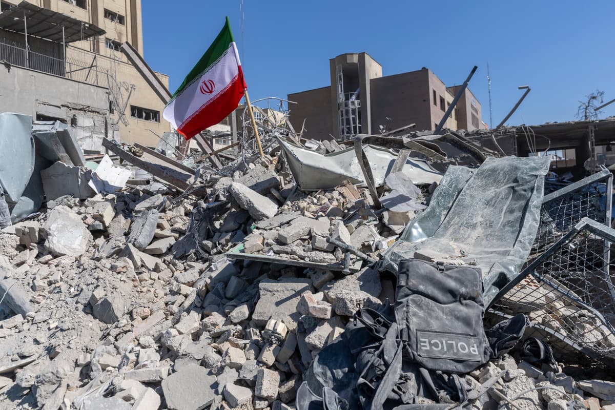 An Iranian flag is planted in the rubble of a police station, damaged in airstrikes on Tehran.