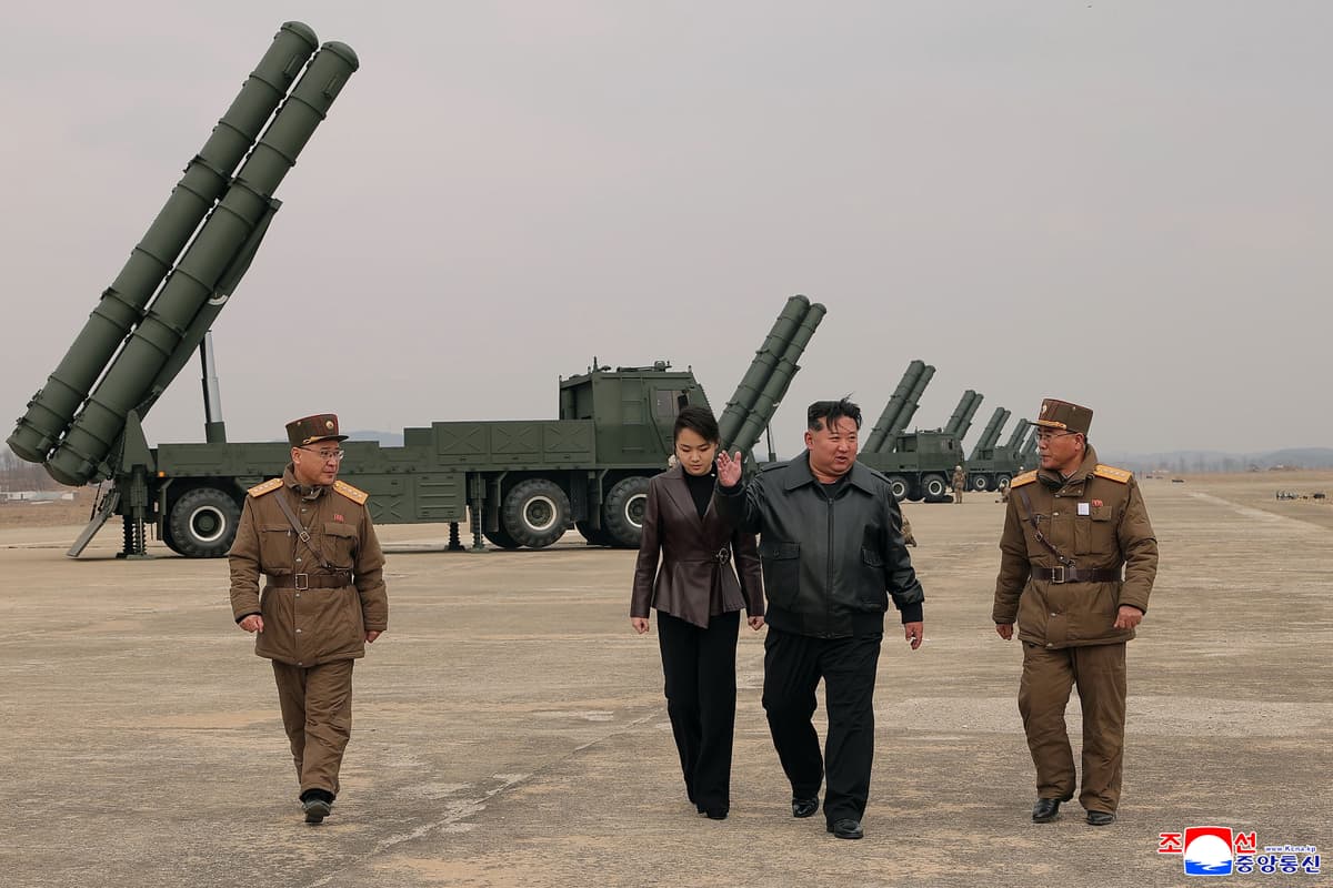 In this photo provided by the North Korean government, its leader Kim Jong Un, center right, and his daughter, center left, attend a live-fire test of multiple rocket launch systems.