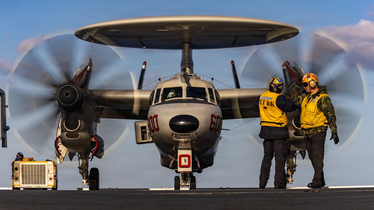 U.S. Navy Sailors signal to an E-2D Hawkeye aircraft, attached to Airborne Command and Control Squadron 124, as it taxis on the flight deck of world's largest aircraft carrier, USS Gerald R. Ford.