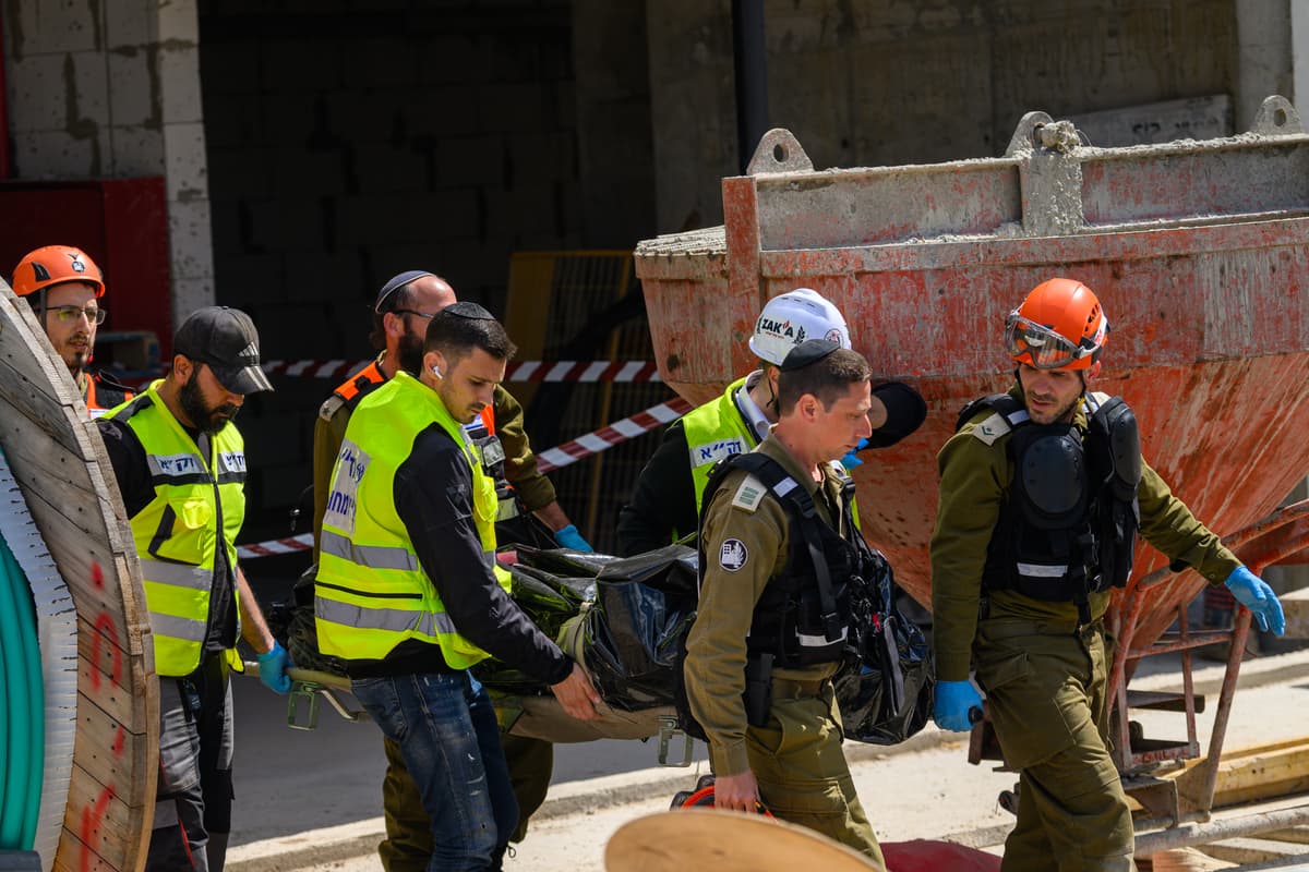 First responders carry a bodybag after at least two people were killed when they were hit by shrapnel from a projectile from a projectile on March 9, 2026 in Yehud, Israel. 