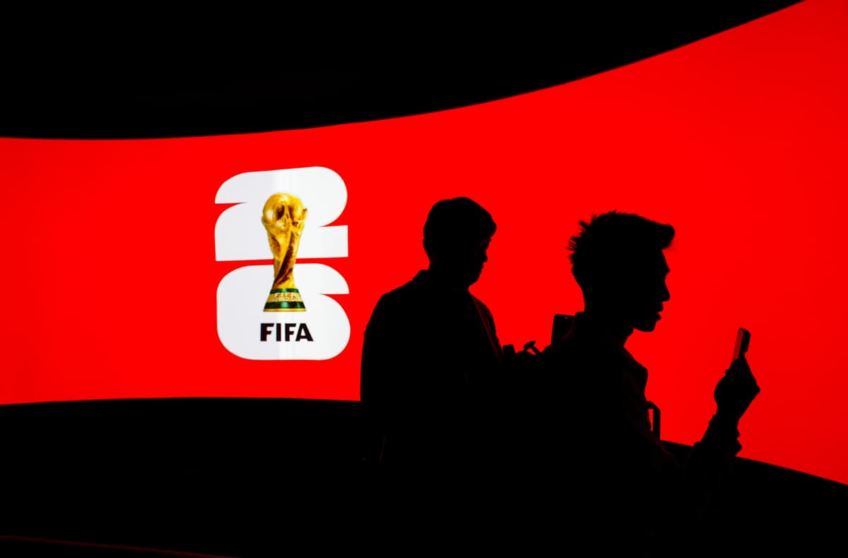 People are silhouetted against a video screen during the launch of the FIFA World Cup trophy tour at Vancouver, Canada, on April 10, 2026. 