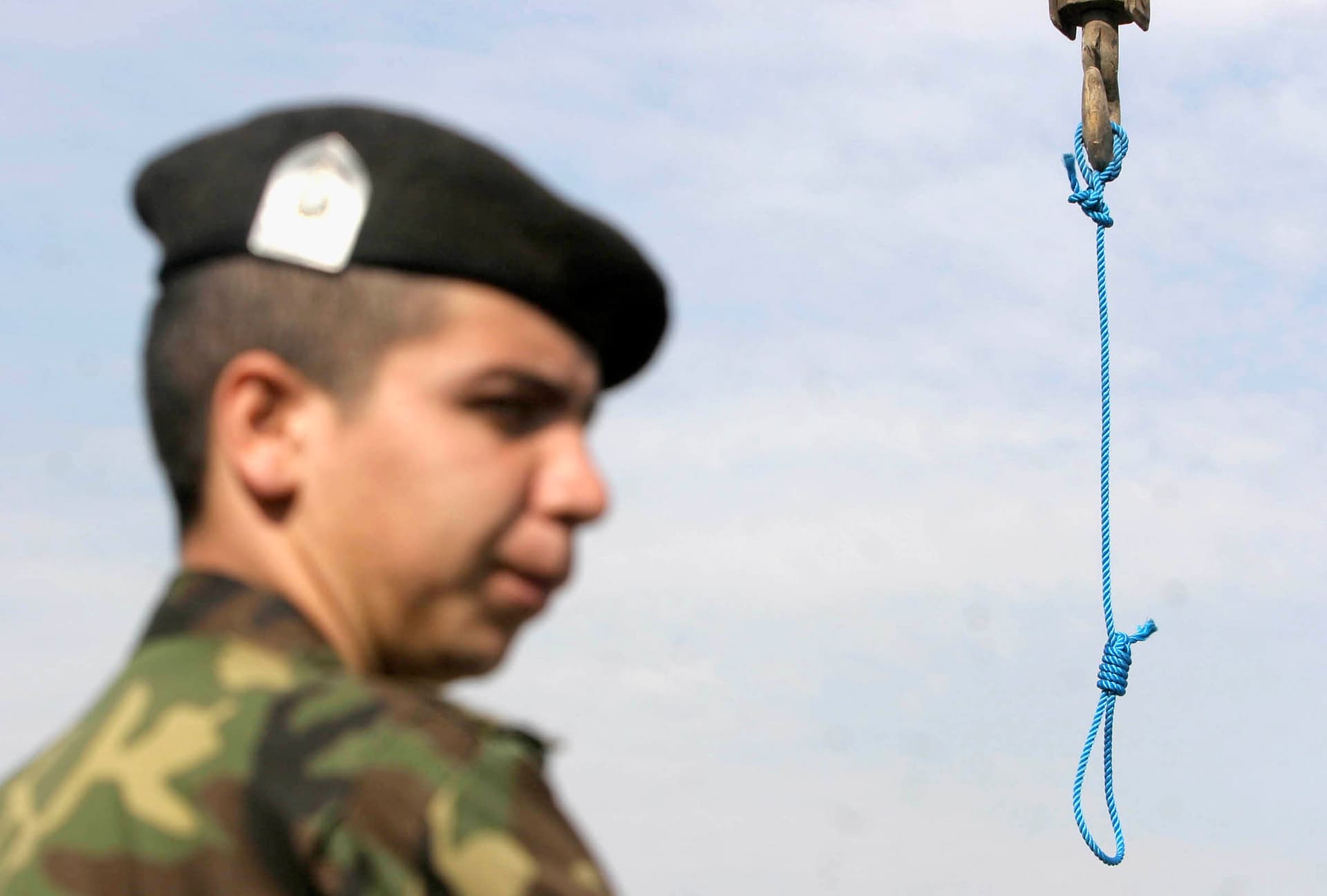 An anti-riot police officer controls the area after a public hanging in Iran.