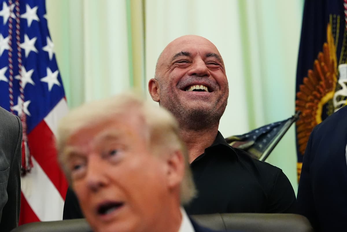 Podcaster Joe Rogan laughs as President Trump jokes about trying a psychedelic drug during a signing ceremony in the Oval Office on April 18, 2026.