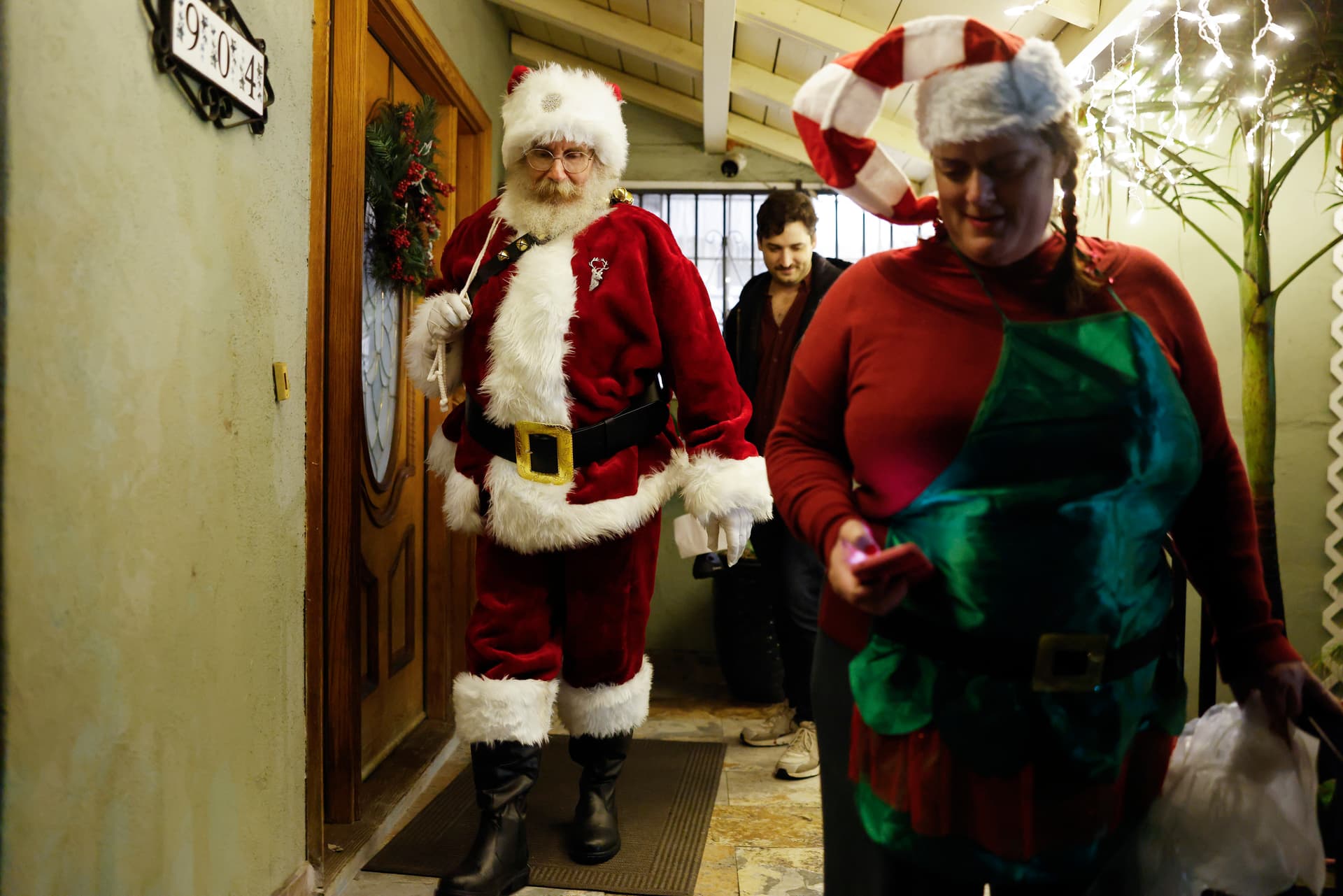 Community advocate René Amy delivers gifts while volunteering as Santa Claus during Pasadena Jaycees’ Operation Santa at Pasadena, California, on December 24, 2025. 