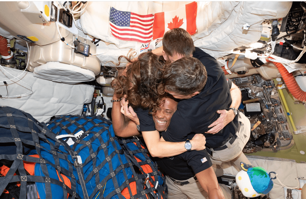 The Artemis II crew — (clockwise from left) Mission Specialist Christina Koch, Mission Specialist Jeremy Hansen, Commander Reid Wiseman, and Pilot Victor Glover — take time out for a group hug inside the Orion spacecraft on their way home April 6, 2026.