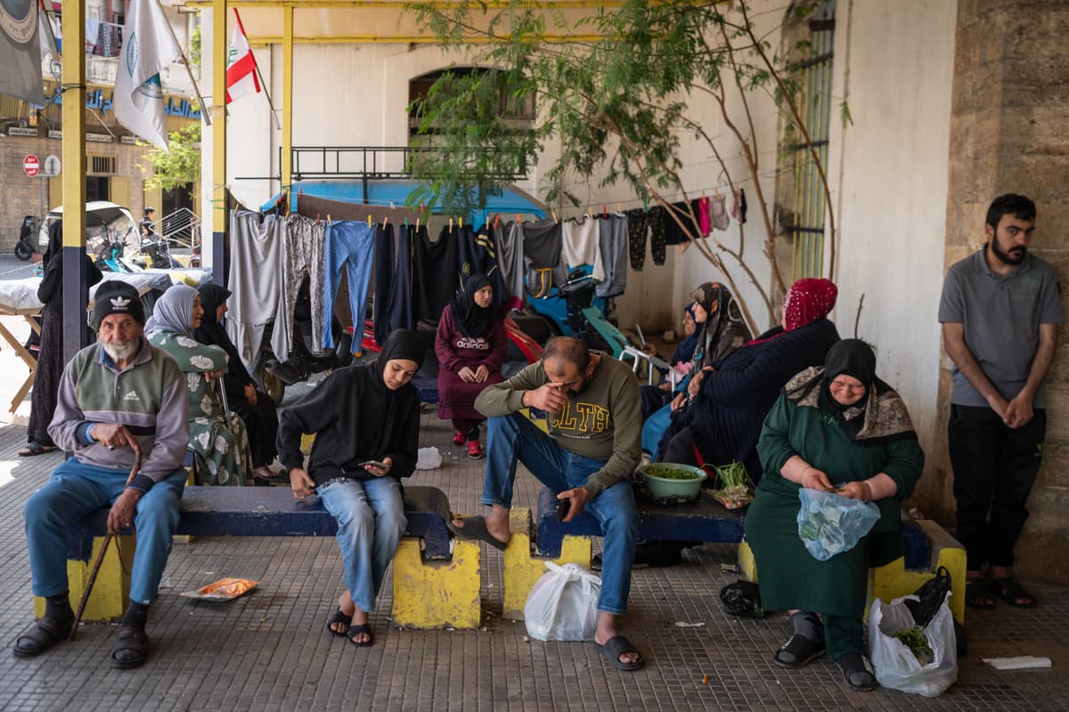 Families sit in front of a shelter for internally displaced people at Sidon, Lebanon, on April 27, 2026.