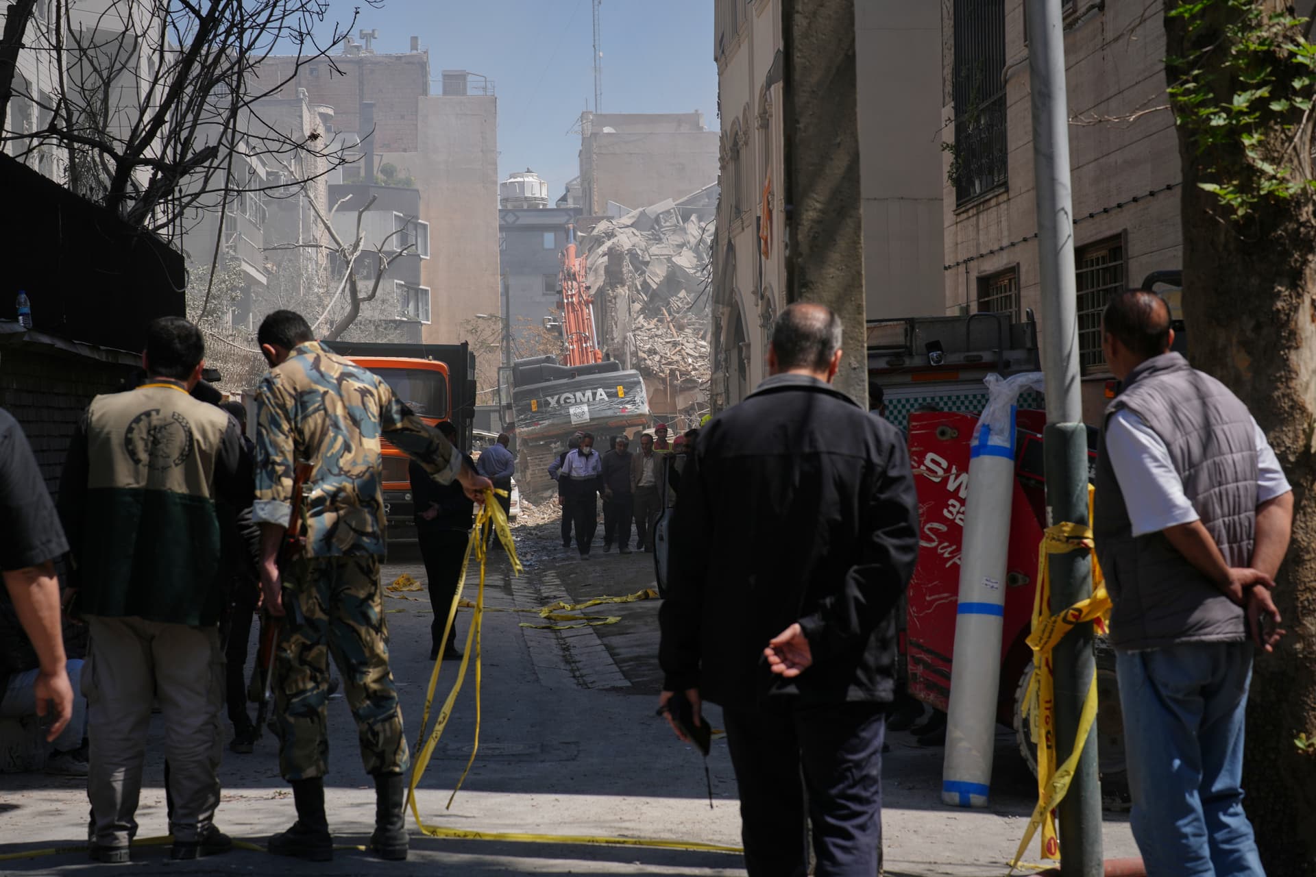 Bystanders watch as rescue teams work at the site of a strike that, according to a security official at the scene, destroyed half of the Khorasaniha Synagogue and nearby residential buildings in Tehran on April 7, 2026.