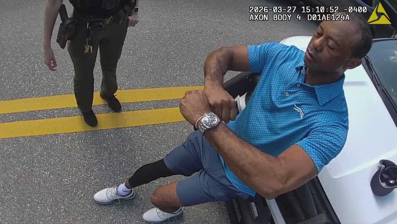 Tiger Woods is interviewed by officers before he's arrested for DUI following a rollover crash on Jupiter Island, Florida, last Friday.