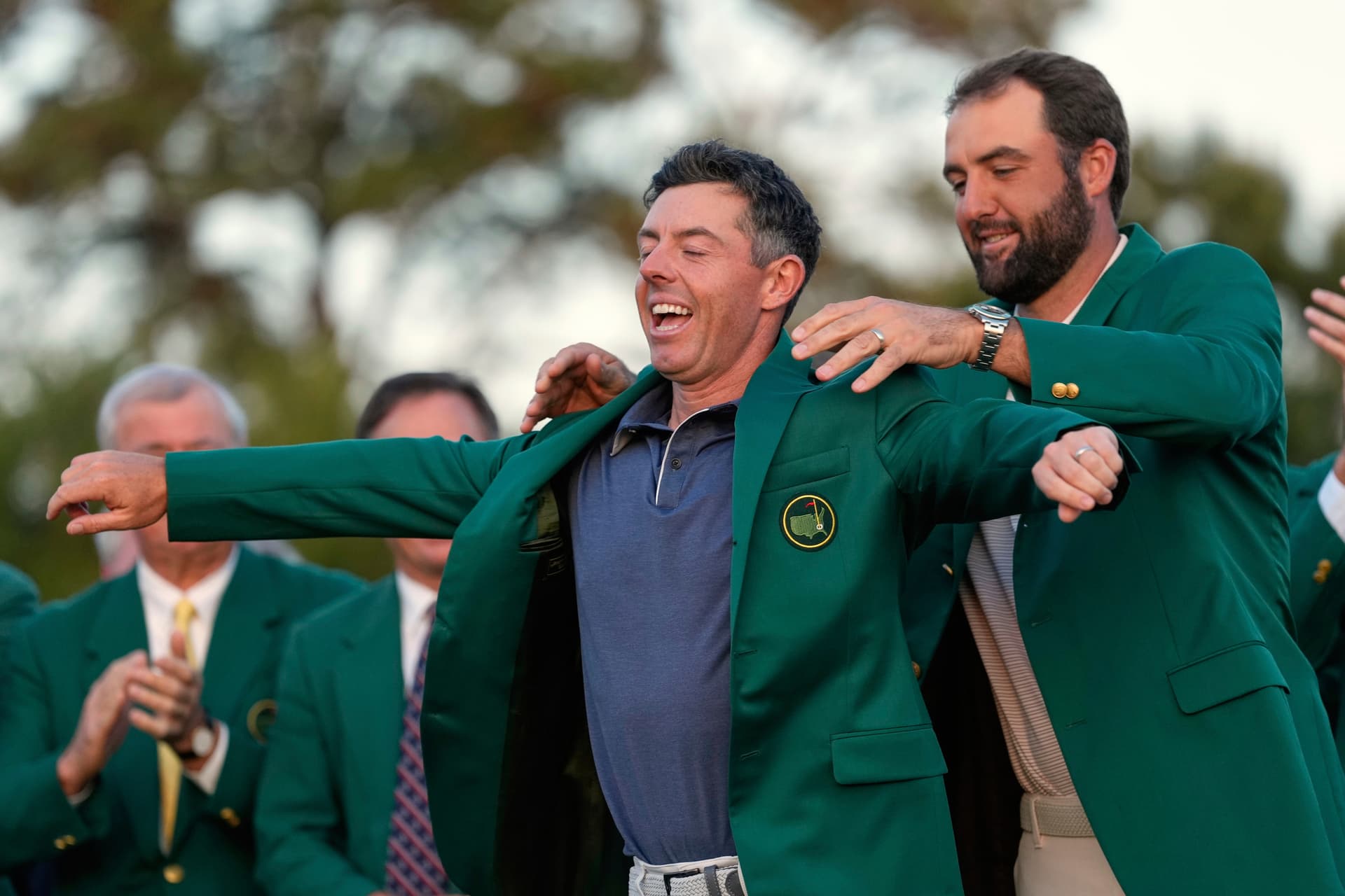 Scottie Scheffler puts the green Jacket on winner, Rory McIlroy, of Northern Ireland, at the Masters golf tournament, April 13, 2025, in Augusta, Georgia.
