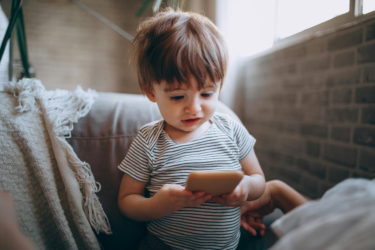 A toddler interacts with a cell phone.