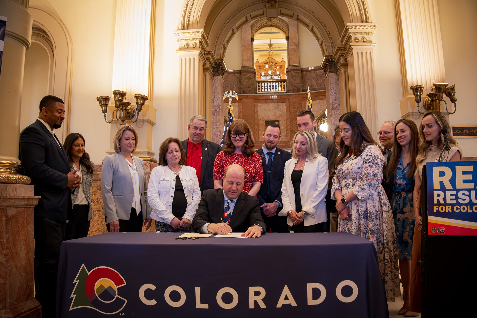 Governor Jared Polis signs legislation at the statehouse at Denver on May 14, 2026.