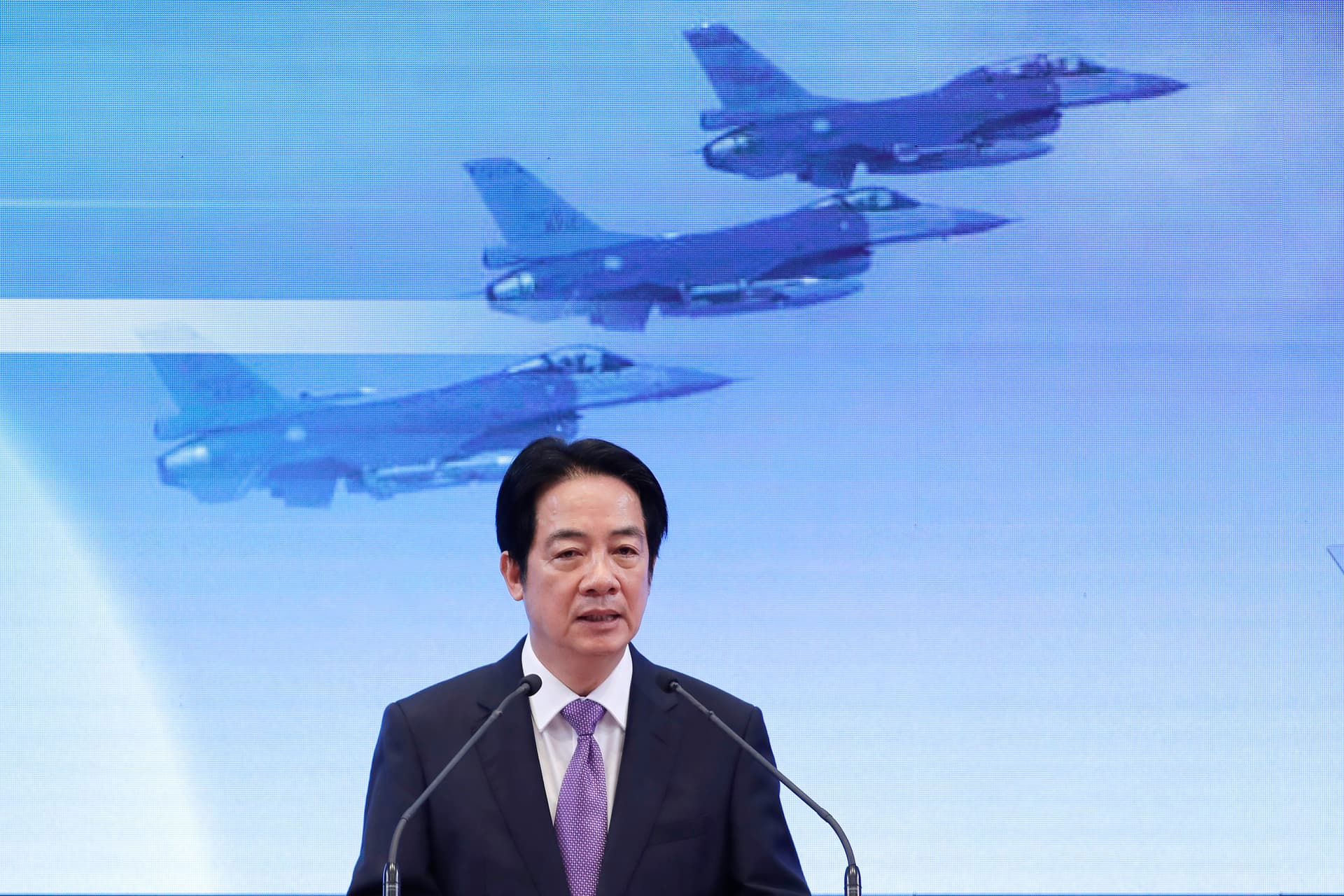 President Lai Ching-te of Free China speaks in front of a video screen showing jet fighters in flight during a press conference at Taipei, Taiwan, on May 20, 2026.