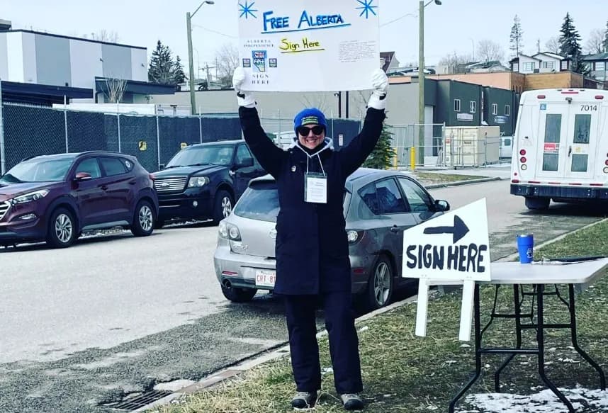 An Alberta separatist holds up a sign seeking signatures to support a ballot question on breaking away from Canada. 