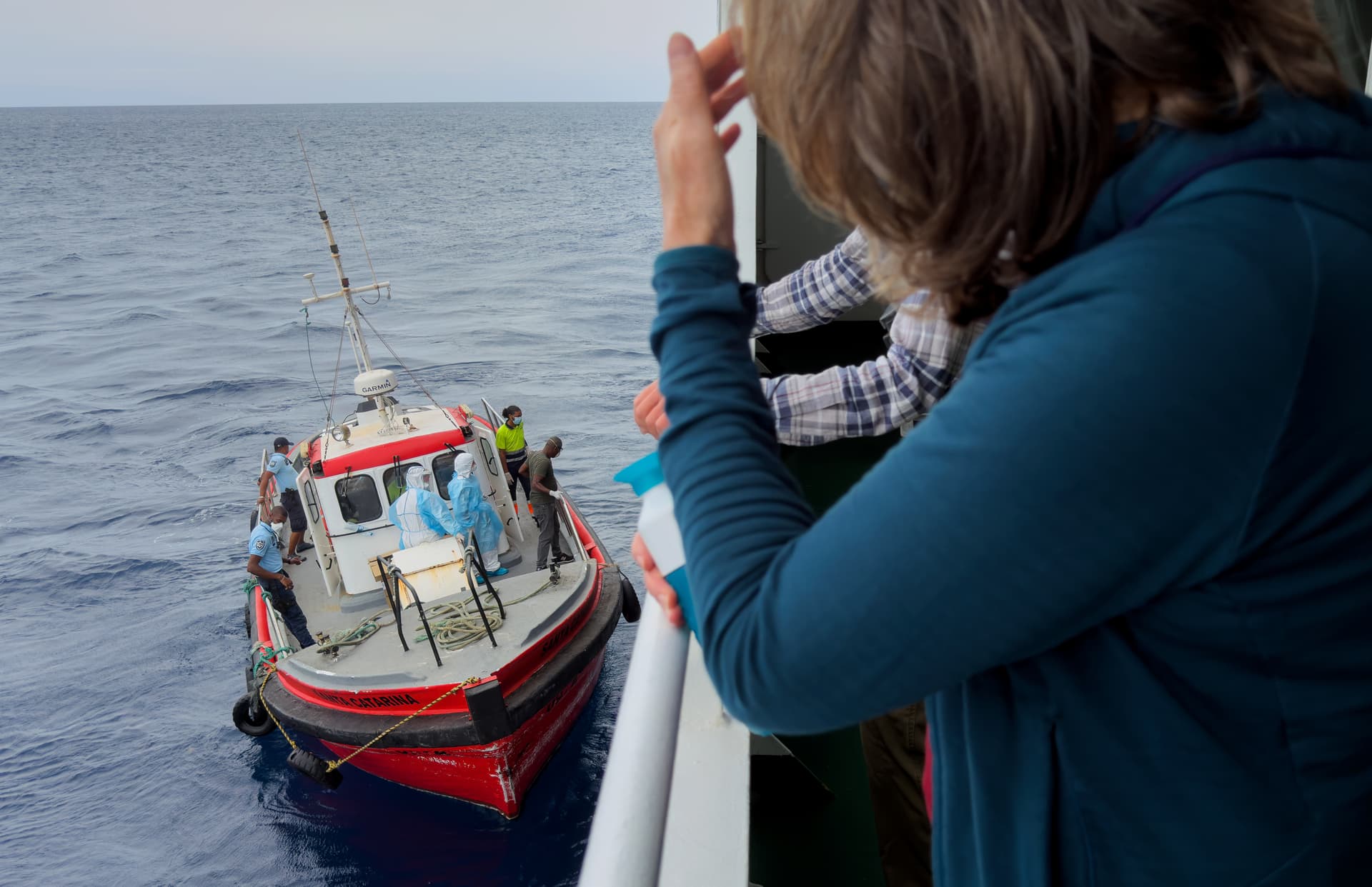 Passengers on the hantavirus-stricken cruise ship, MV Hondius, watch epidemiologists board the ship at Praia, Cape Verde, on May 6, 2026. 