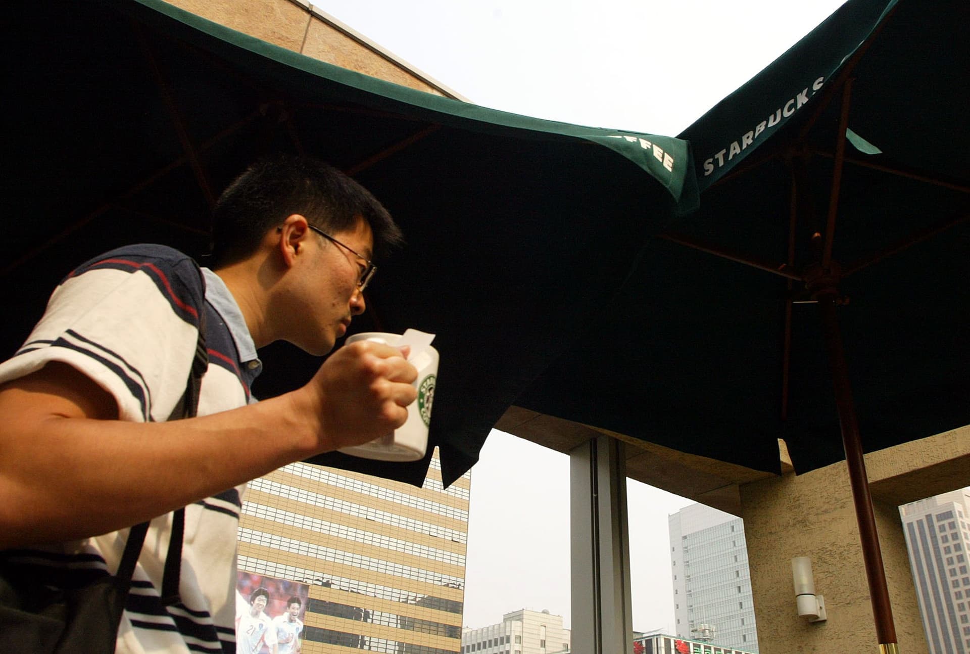 A customer drinks a beverage from Starbucks coffee store in Seoul, South Korea. 