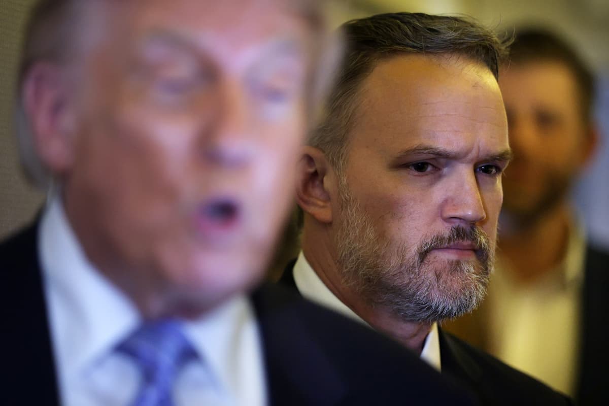 U.S. Trade Representative Jamieson Greer listens as President Trump speaks to reporters aboard Air Force One on May 15, 2026, as he returns to the United States from China.