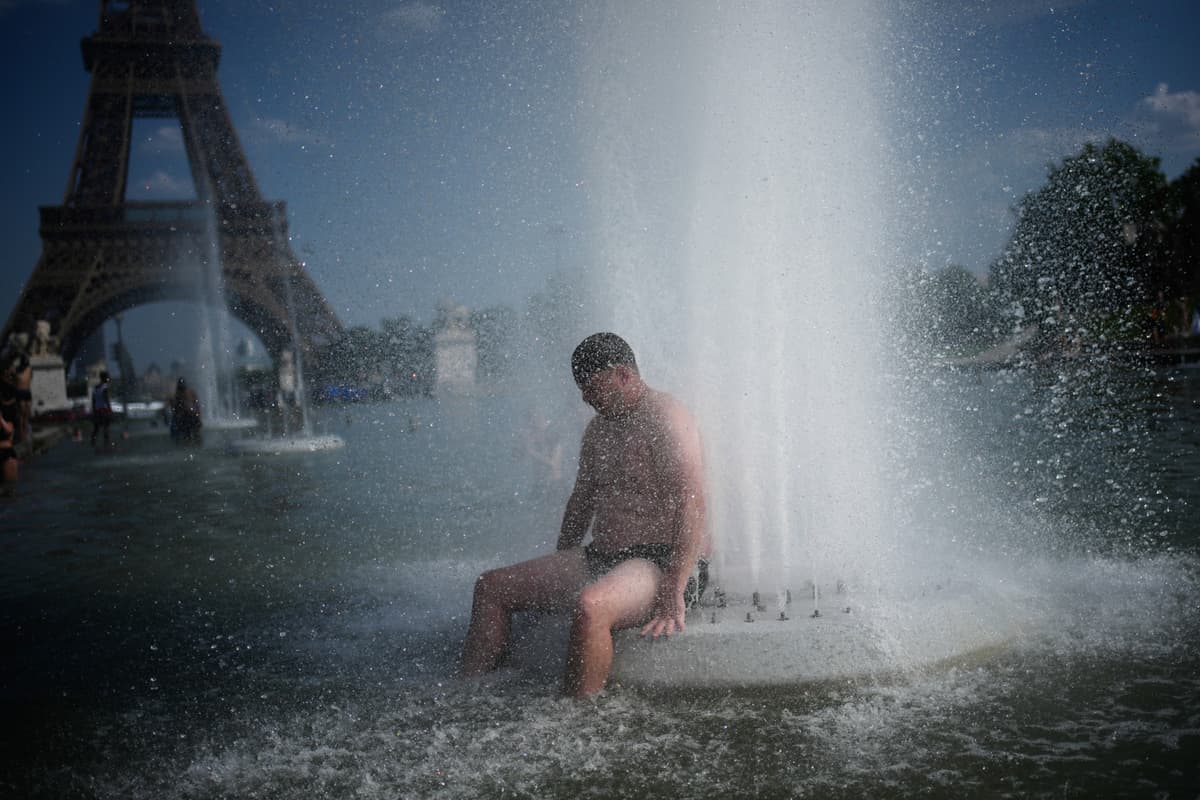 A person cools off at Trocadero fountain near the Eiffel Tower during a heat wave at Paris on June 24, 2026. 