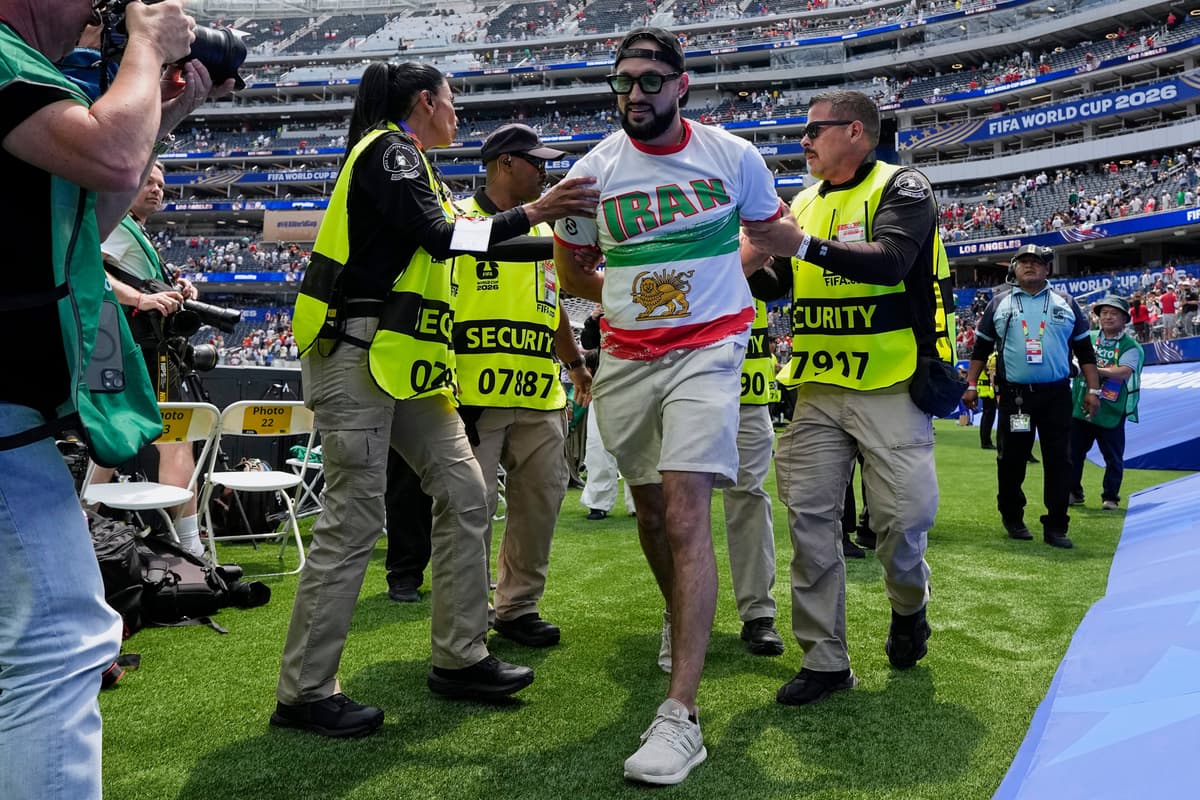 An Iranian fan is removed from the field at the end of a World Cup soccer match between Belgium and Iran at Los Angeles Stadium at Inglewood, California, on June 21, 2026.