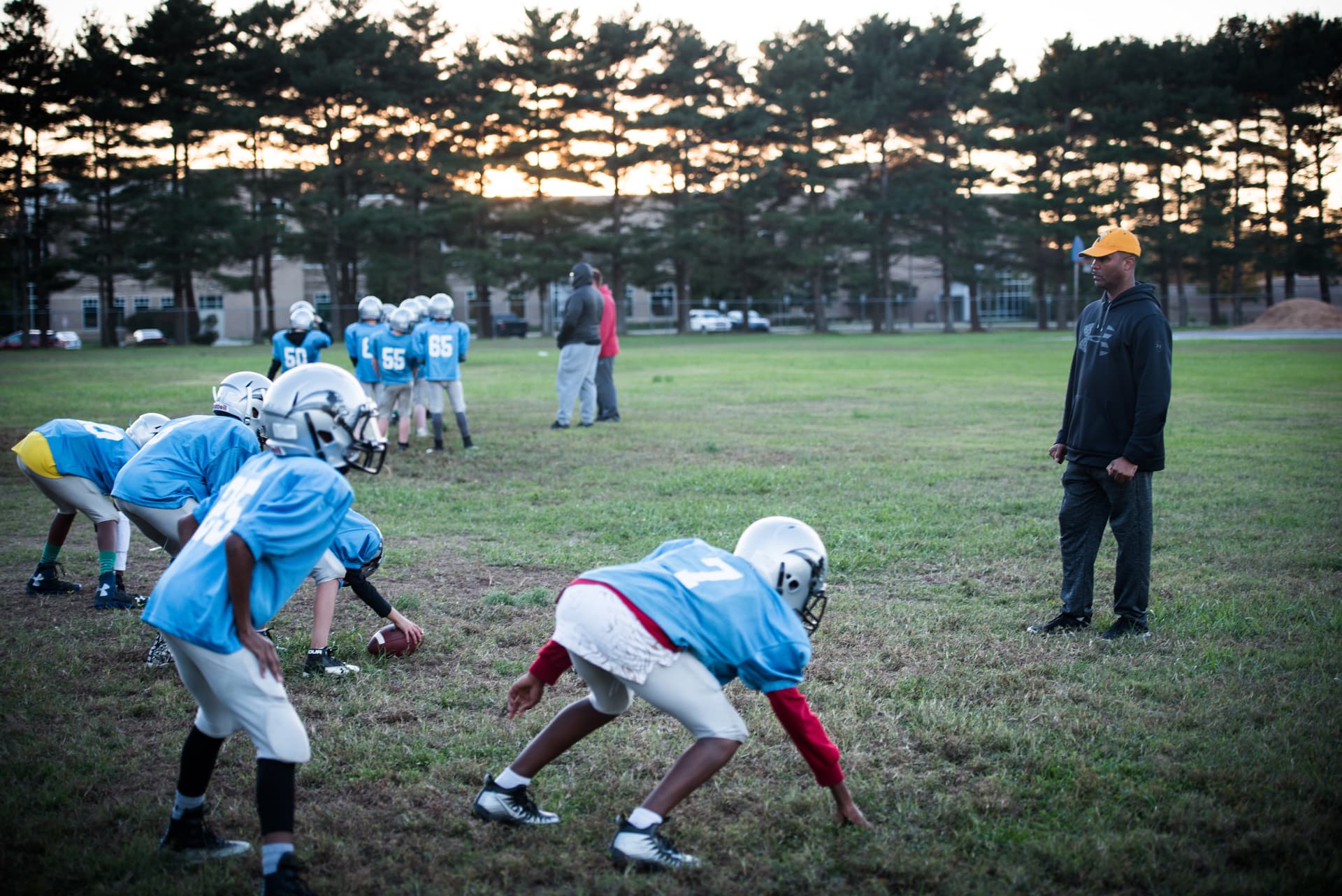 A football coach supervises practice drills.