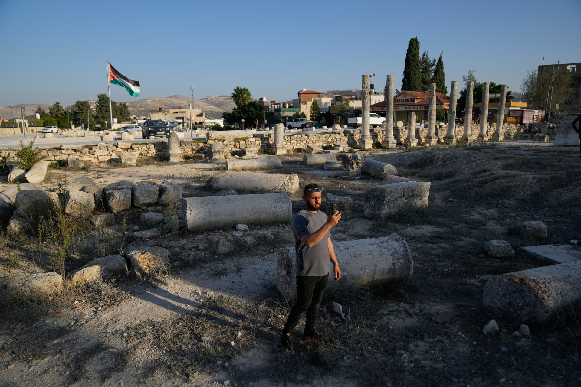 A Palestinian visitor takes a photo at the West Bank historical site of Sebastia, considered to be the ancient capital of Northern Israel, Samaria on November 20, 2025.