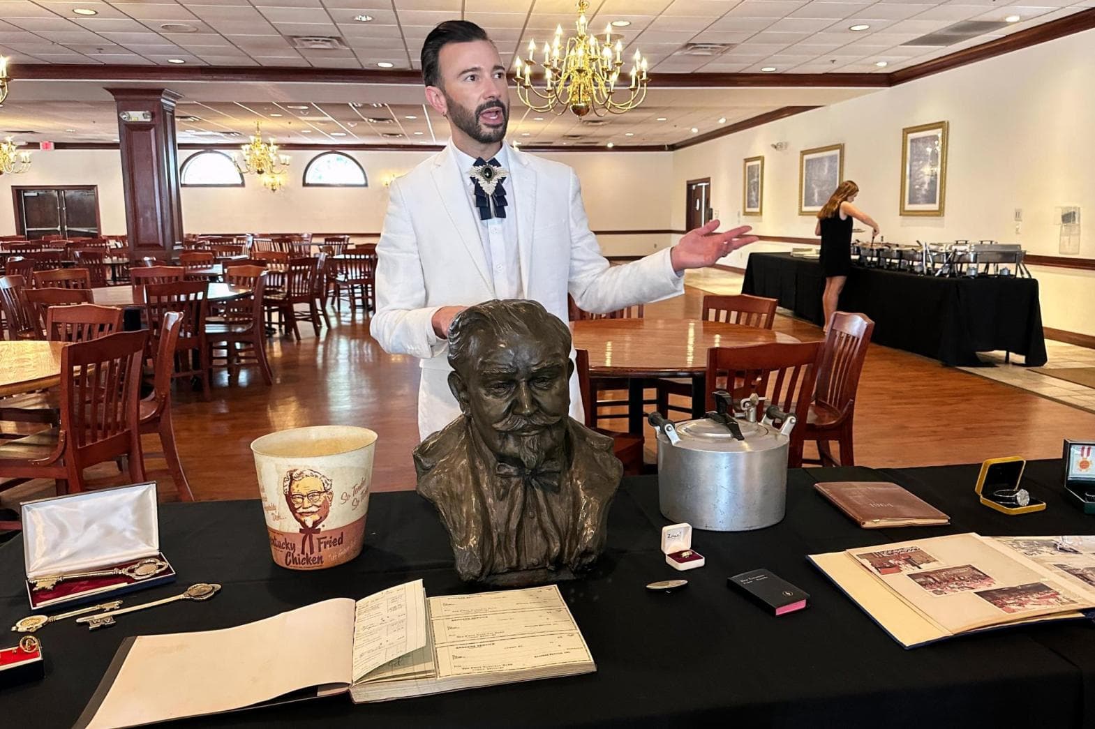 Auctioneer Jonathan Klunk surrounded by items owned by Colonel Sanders on July 22, 2026, in Shelbyville, Kentucky. 