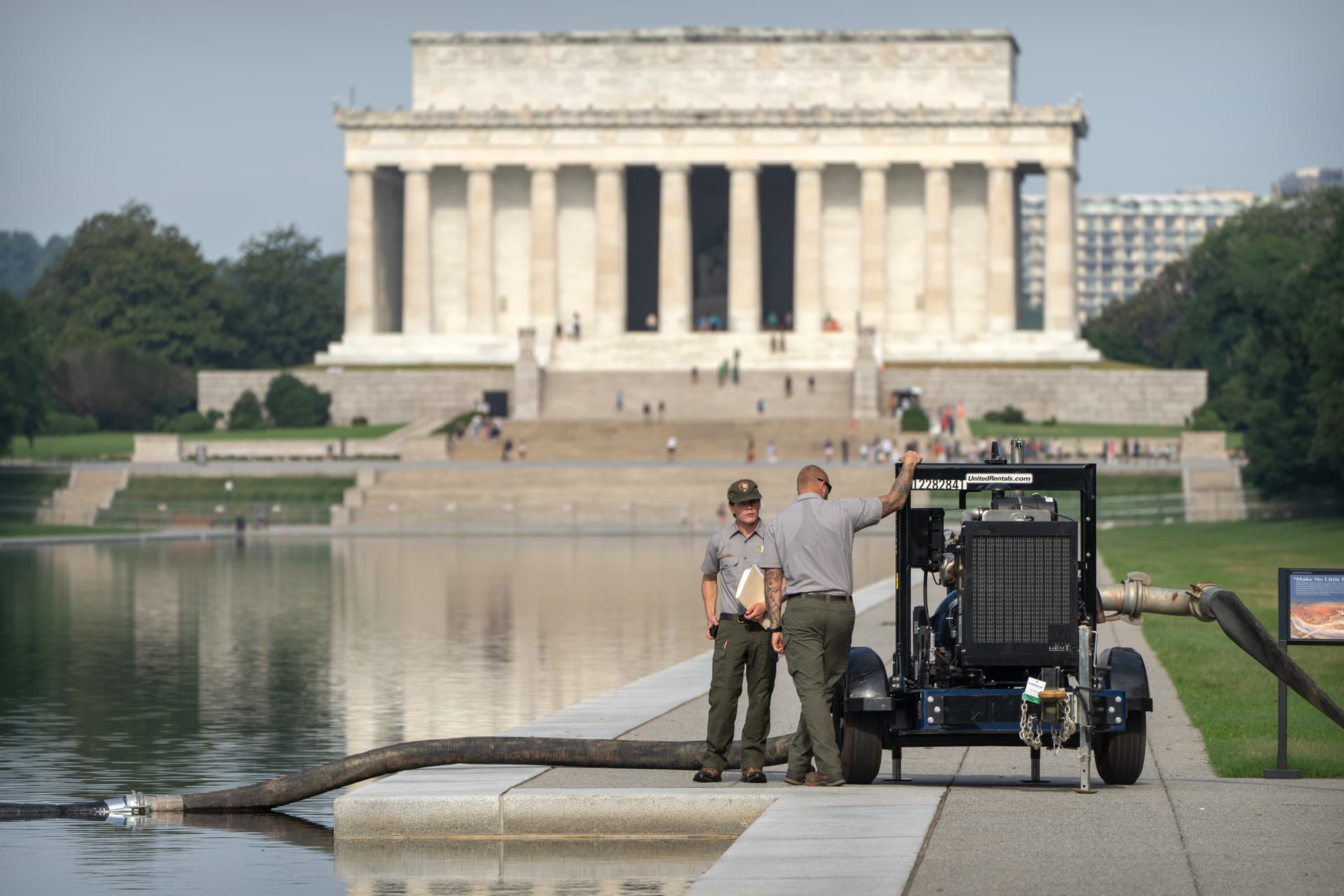 National Park Service workers stand near a pump placed next to the Lincoln Memorial Reflecting Pool at Washington, D.C., on July 10, 2026.