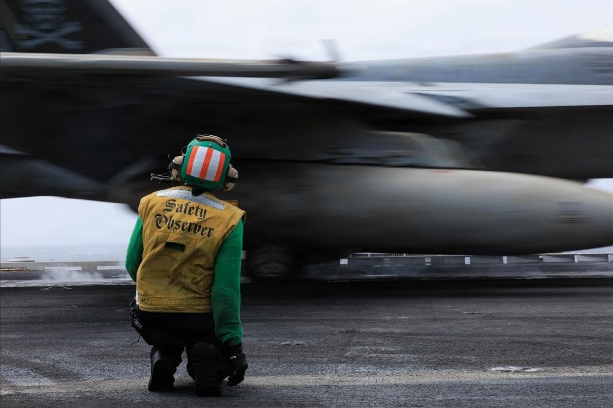 U.S. Sailors monitor F/A-18E Super Hornet fighter jets launching from the USS George H.W. Bush while sailing in the Arabian Sea.