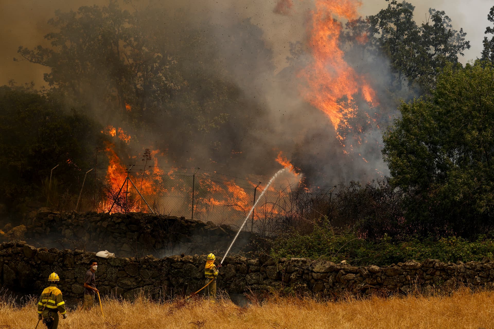  Firefighters battle a wildfire as it approaches houses in Ávila province, Spain, on July 24, 2026.