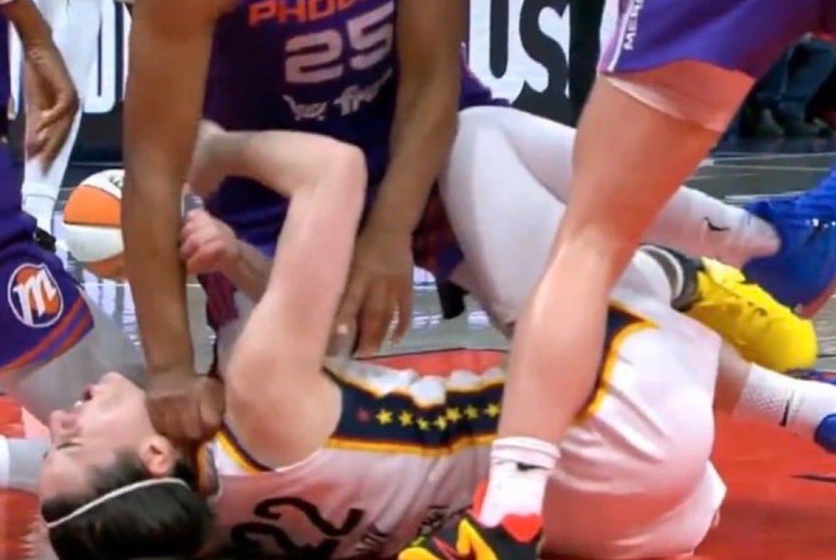 Alyssa Thomas pushes her fist into Caitlin Clark's neck.