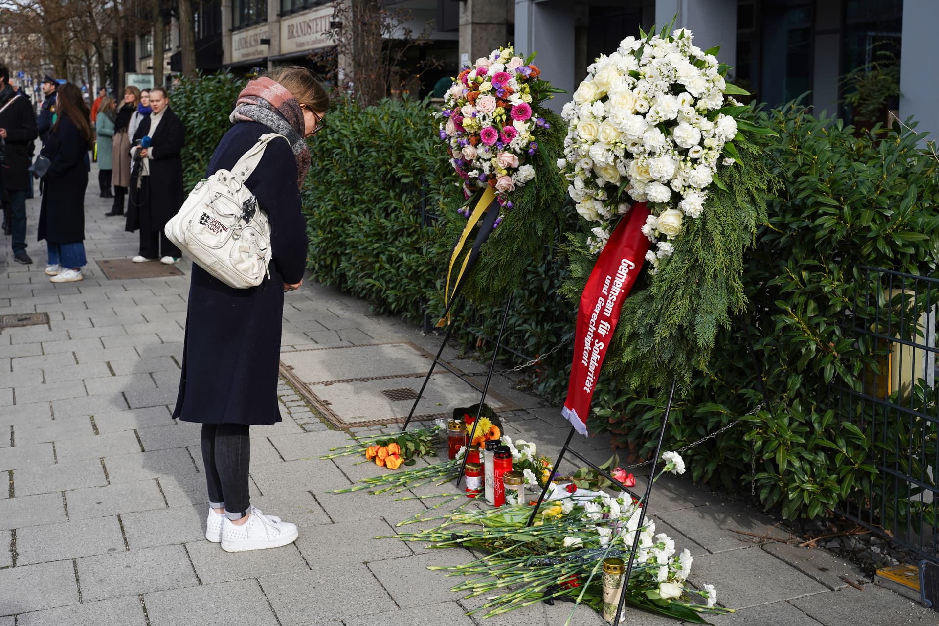 Residents of Munich lay flowers to commemorate the victims of the 2025 car attack on February 13, 2026 in Munich, Germany. A 37-year-old woman and her two-year-old daughter died from their injuries, at least 44 people were wounded, and police arrested a 24-year-old Afghan asylum seeker after a car drove into the crowd at the rally. 