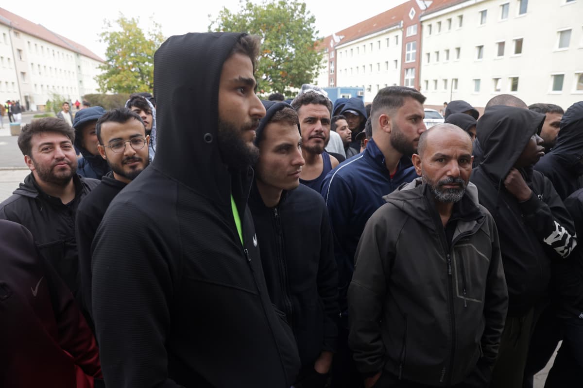 Men, most of them from Syria, line up for lunch at a reception facility for migrants and refugees at Eisenhuettenstadt, Germany, on October 5, 2023.