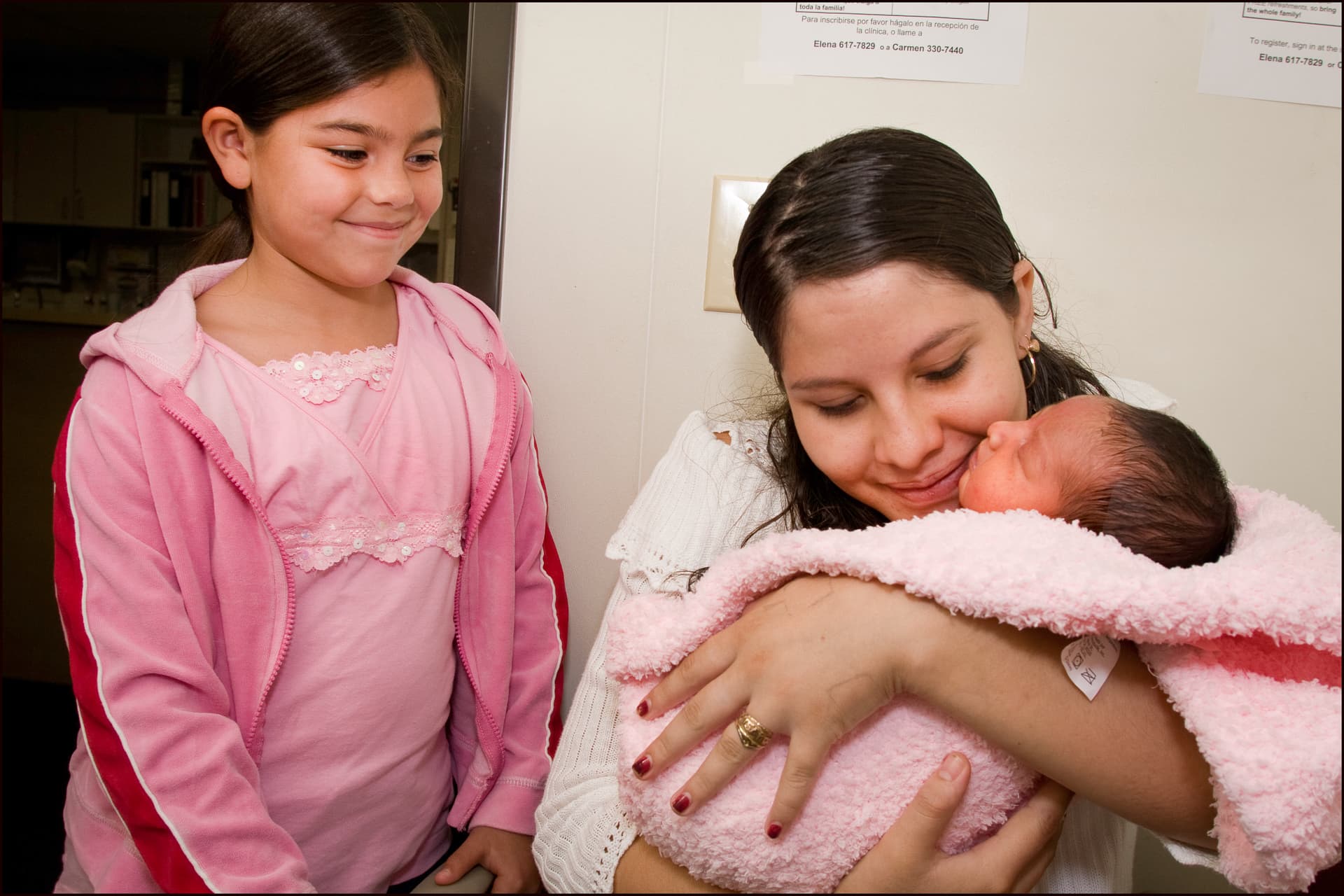 An unidentified teenage mother holds her 3-day-old infant at a health clinic at East Palo Alto, California, on June 19, 2007.