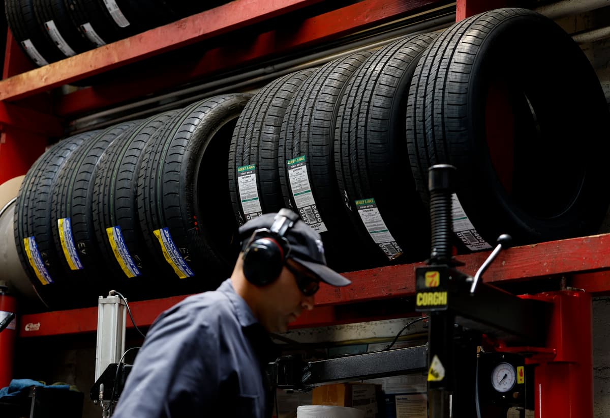 A worker mounts a tire at Robert's Tire and Wheels at San Francisco, California, on August 12, 2025.