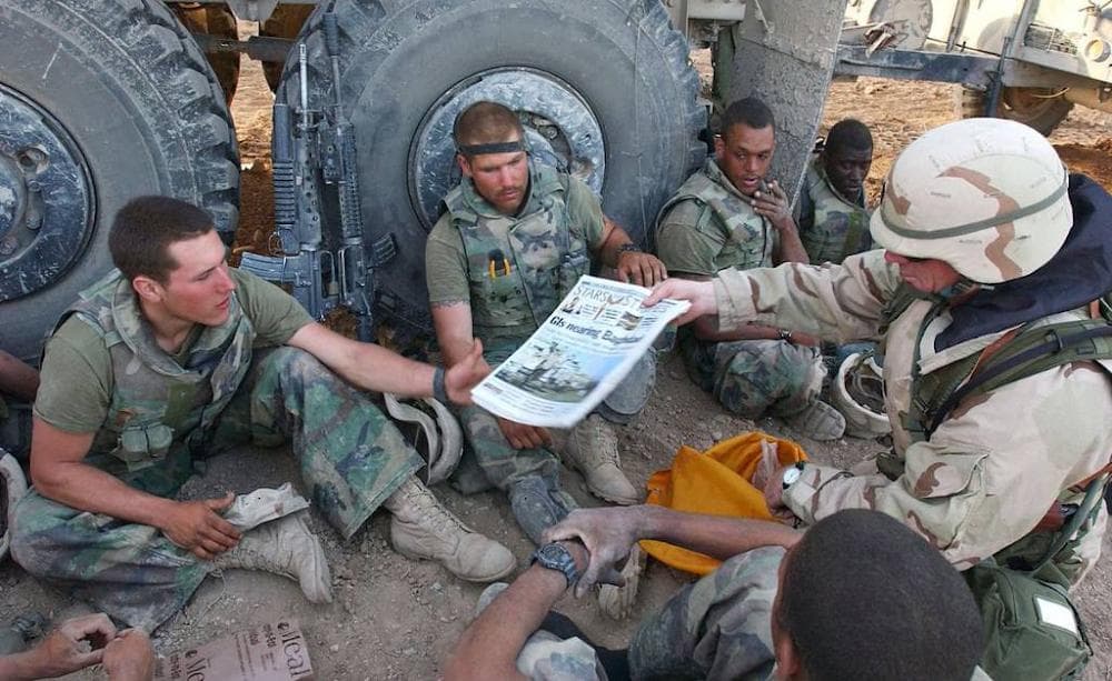 American Marines in Iraq receive copies of the Stars and Stripes newspaper during the drive toward Baghdad on April 4, 2003.