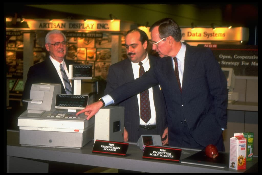 President Bush (R) inspecting supermarket checkout-counter technology at the National Grocers Association convention.