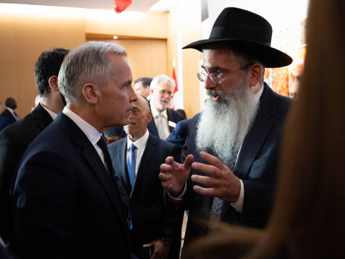 Prime Minister Mark Carney speaks with an attendee during a visit to Holy Blossom Temple at Ontario, Canada, on June 1, 2026.
