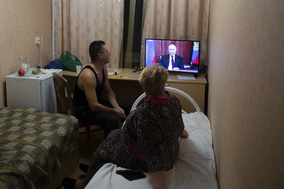 People from the Donetsk and Luhansk regions, the territory controlled by a pro-Russia separatist governments in eastern Ukraine, watch President Putin on TV, February 21, 2022. AP/Denis Kaminev
