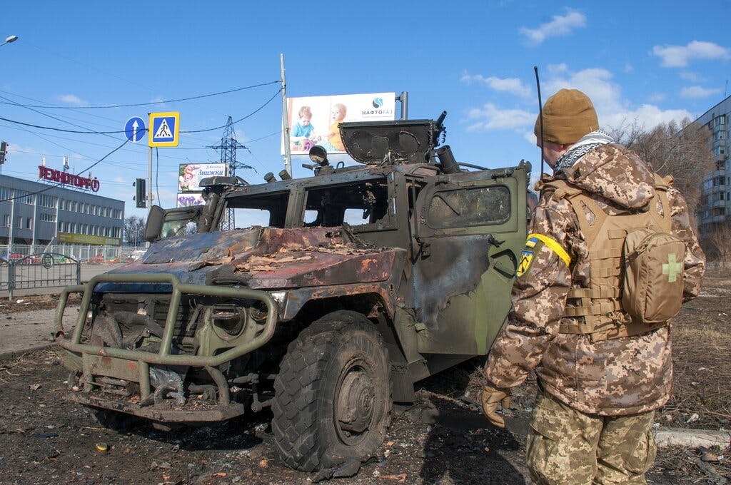 A Ukrainian soldier inspects a damaged military vehicle after fighting at Kharkiv February 27, 2022. AP/Marienko Andrew